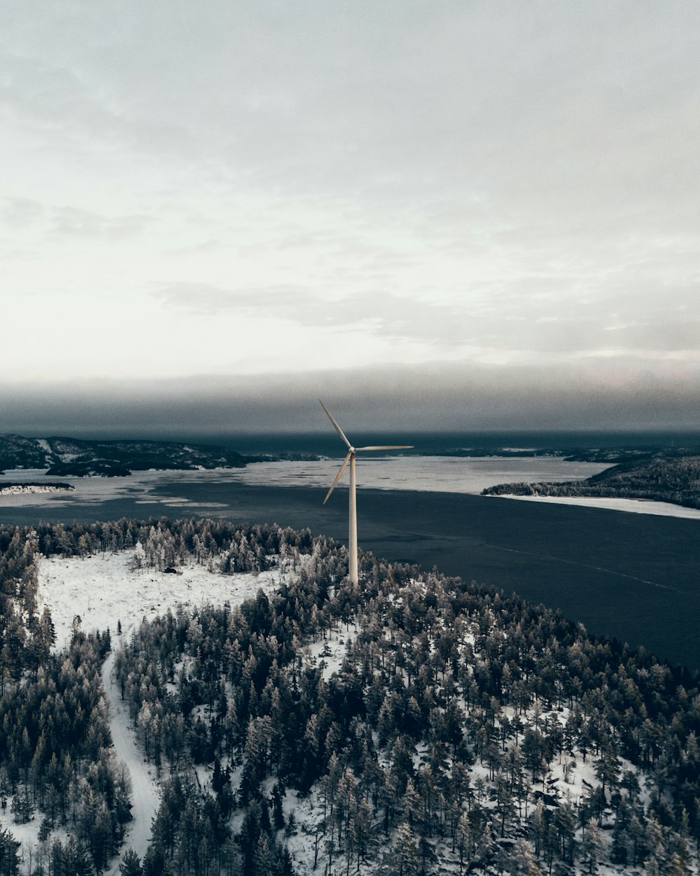 white wind turbine on snow covered ground during daytime