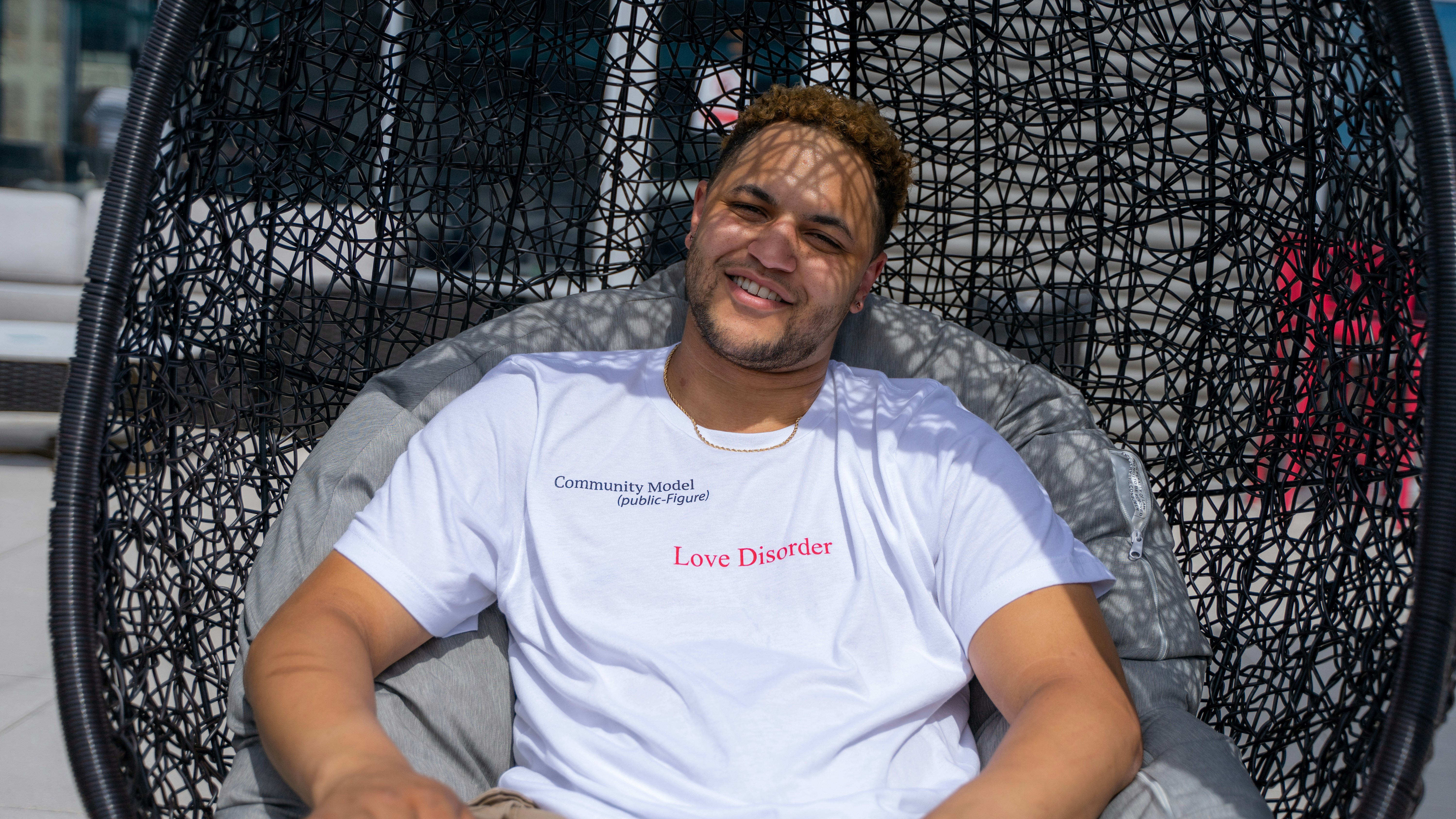 man in white crew neck t-shirt sitting on gray couch