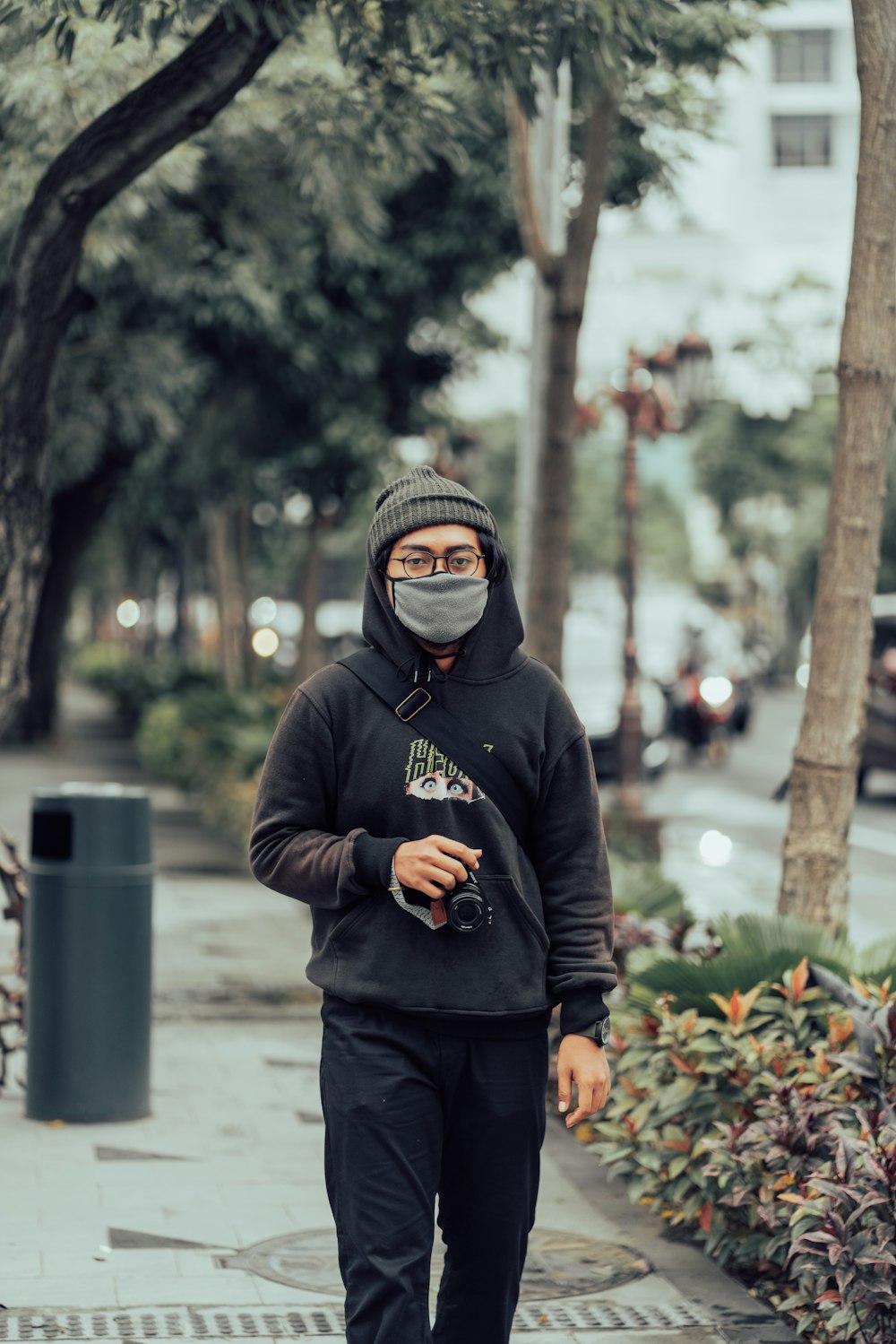 man in black hoodie standing near trees during daytime