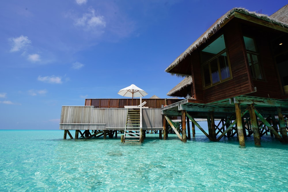 Casa di legno marrone sullo specchio d'acqua durante il giorno