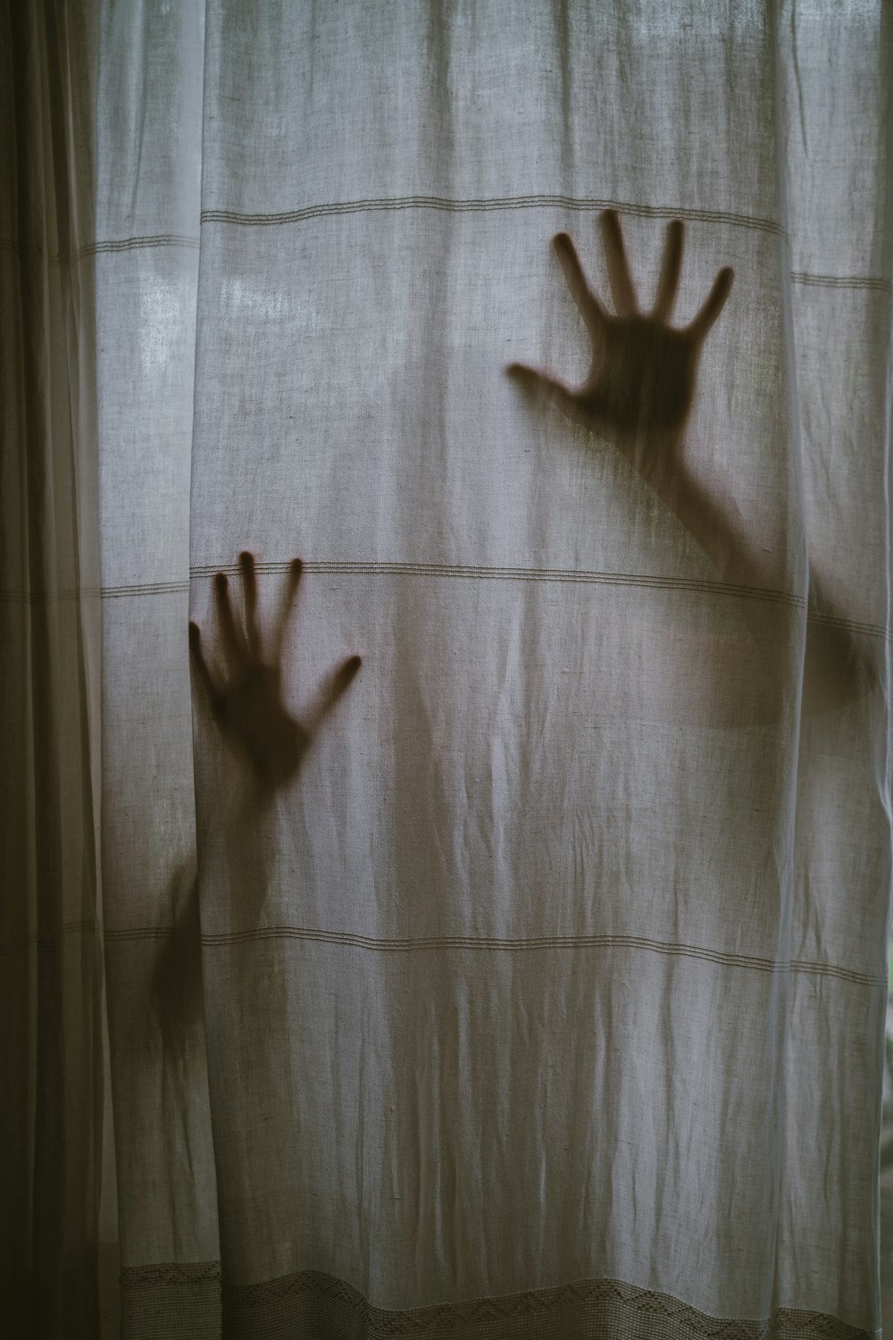 persons hand on white and gray plaid textile