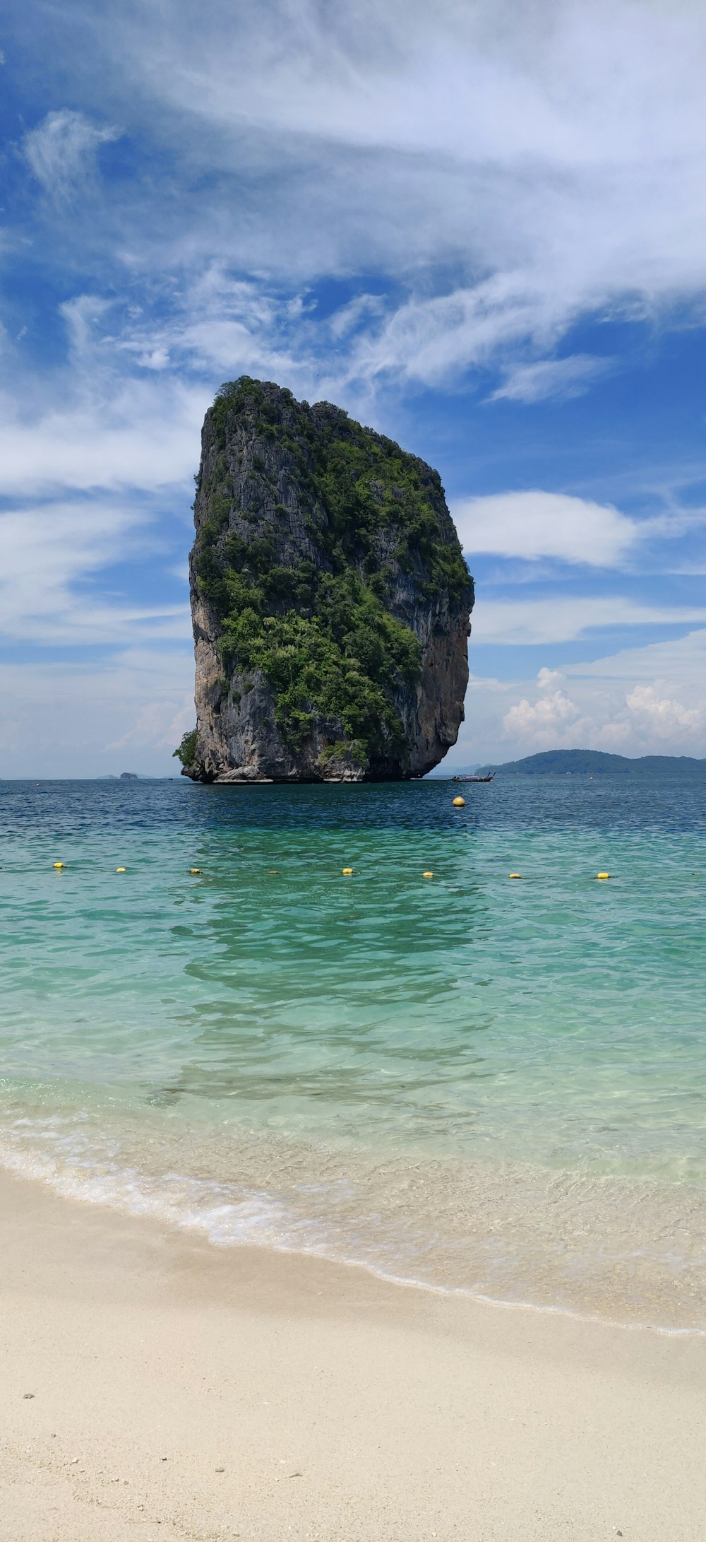 brown rock formation on sea under blue sky during daytime