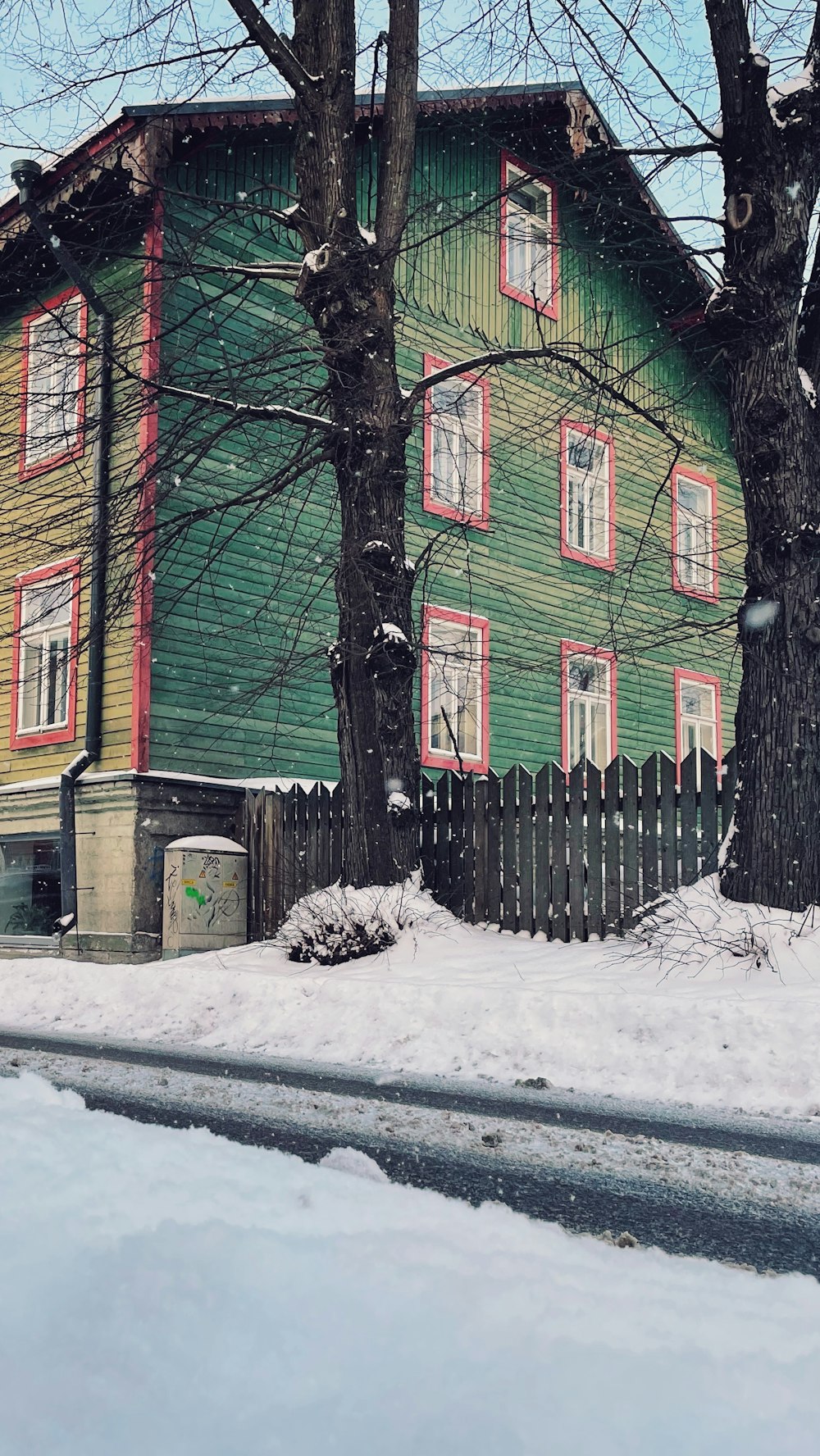 casa vermelha e verde perto de árvores cobertas de neve