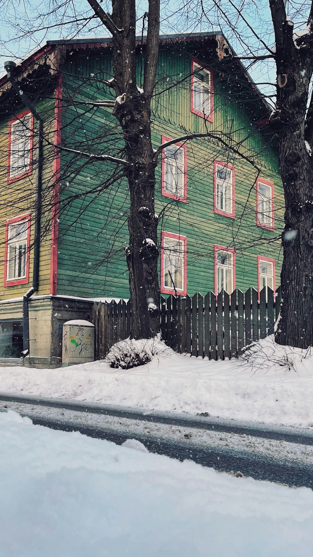 red and green house near trees covered with snow