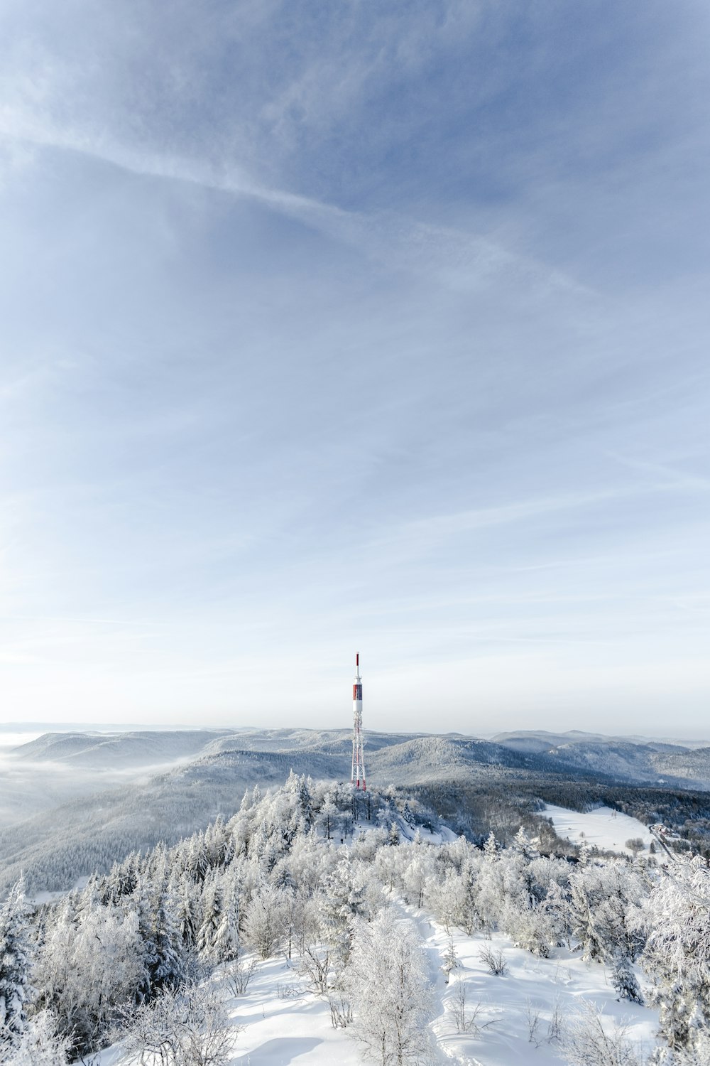 white and red tower on top of mountain