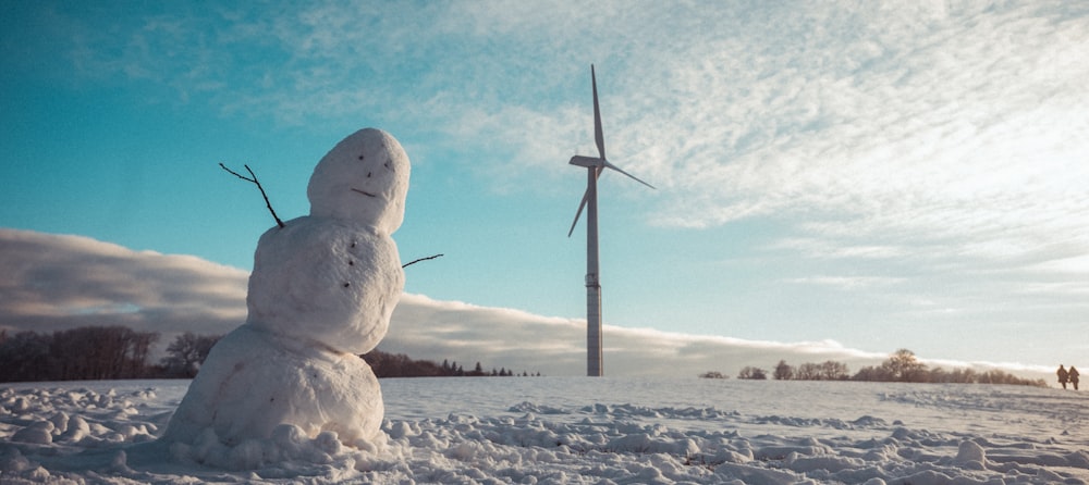 snowman on snow covered ground during daytime