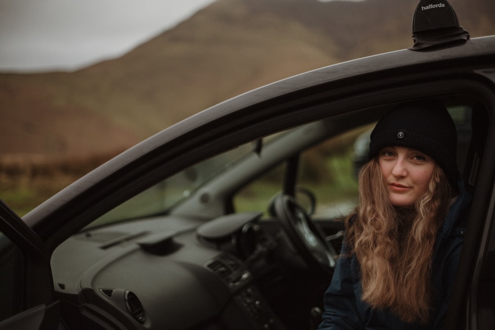 woman in blue denim jacket sitting on driver seat