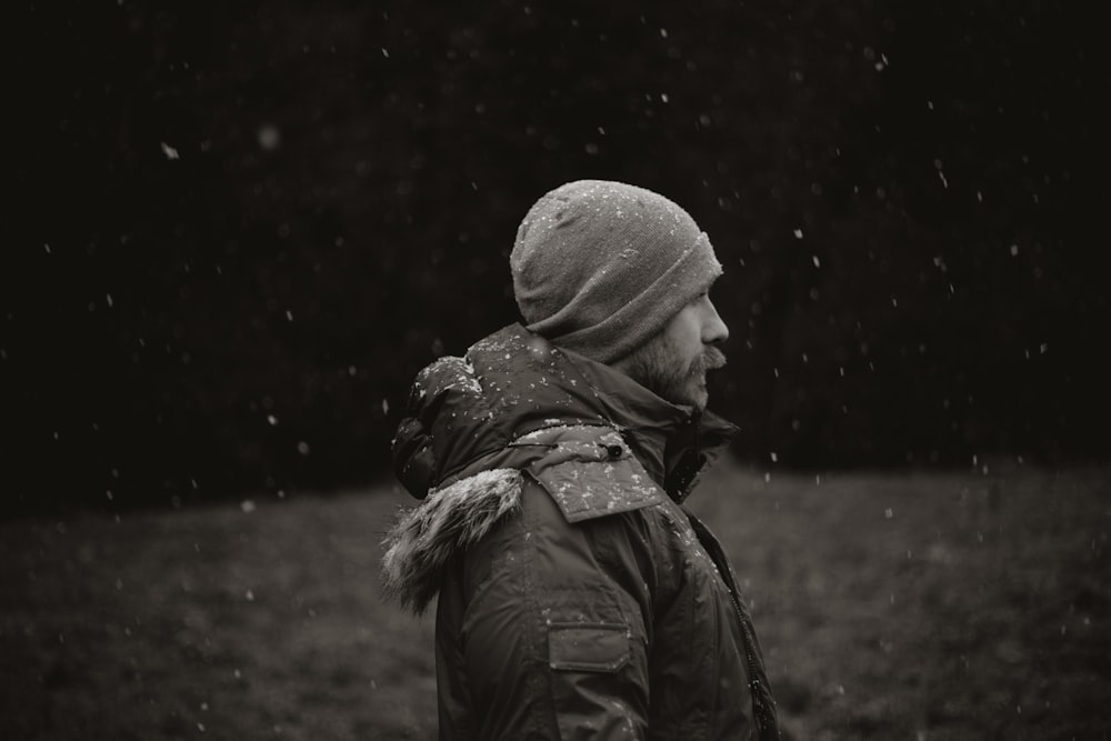 grayscale photo of person in jacket and knit cap