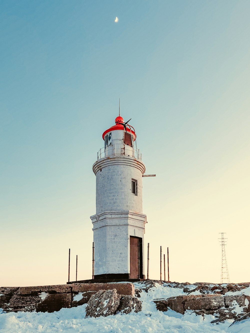 faro bianco e rosso sotto il cielo blu durante il giorno