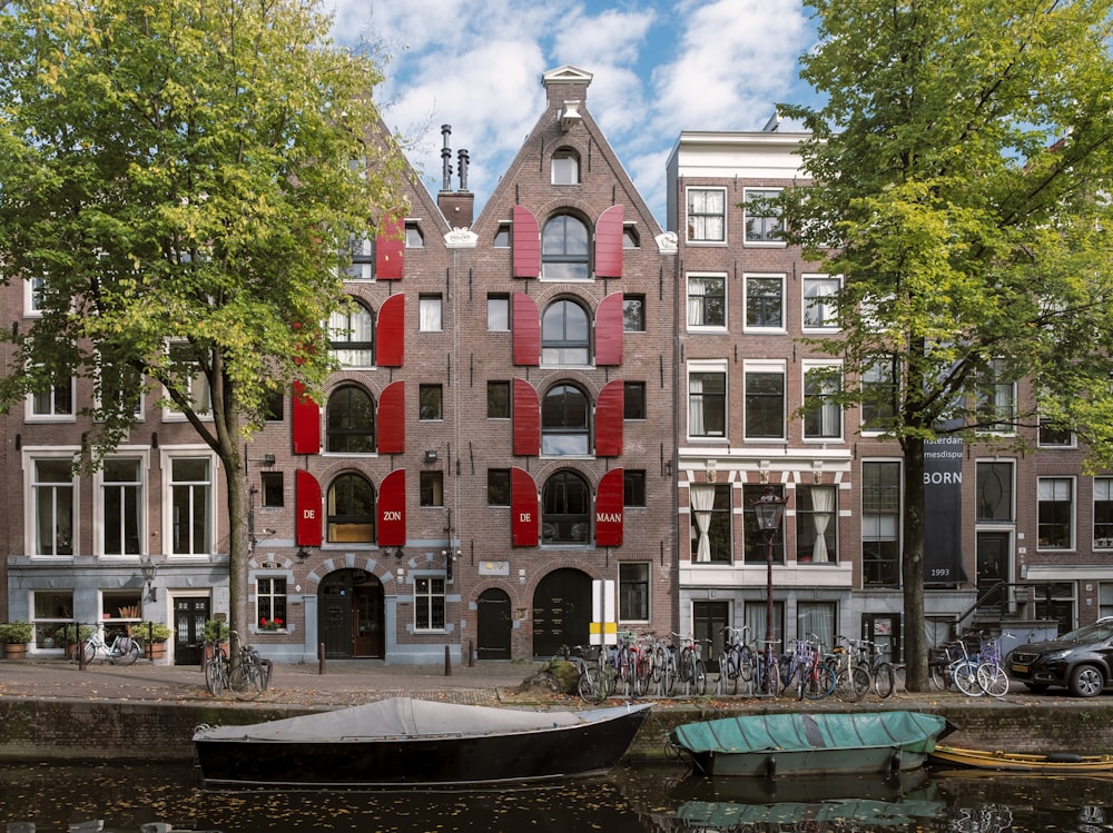 Bâtiment en béton rouge et blanc près d’arbres verts sous des nuages blancs et un ciel bleu pendant la journée