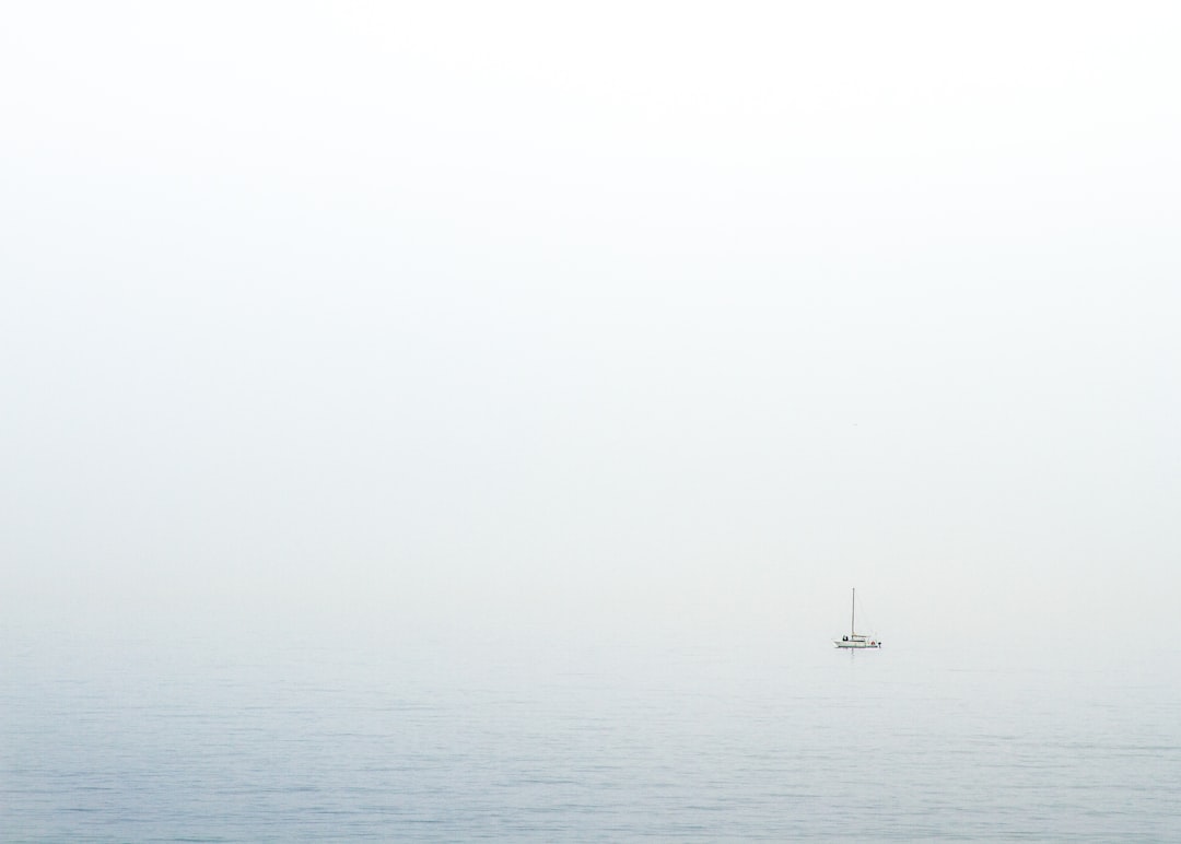 body of water under white sky during daytime