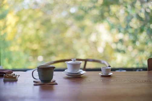 A peaceful London garden with a traditional tea set arranged on a rustic wooden table surrounded by greenery.