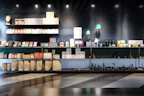 Warm-lit shelf featuring pet supplies next to neat, modern digital gadgets in pastel colors.