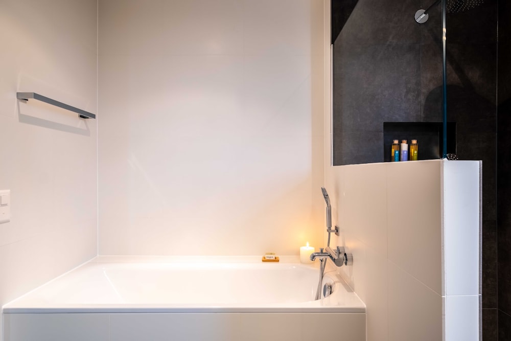 white ceramic bathtub with stainless steel faucet