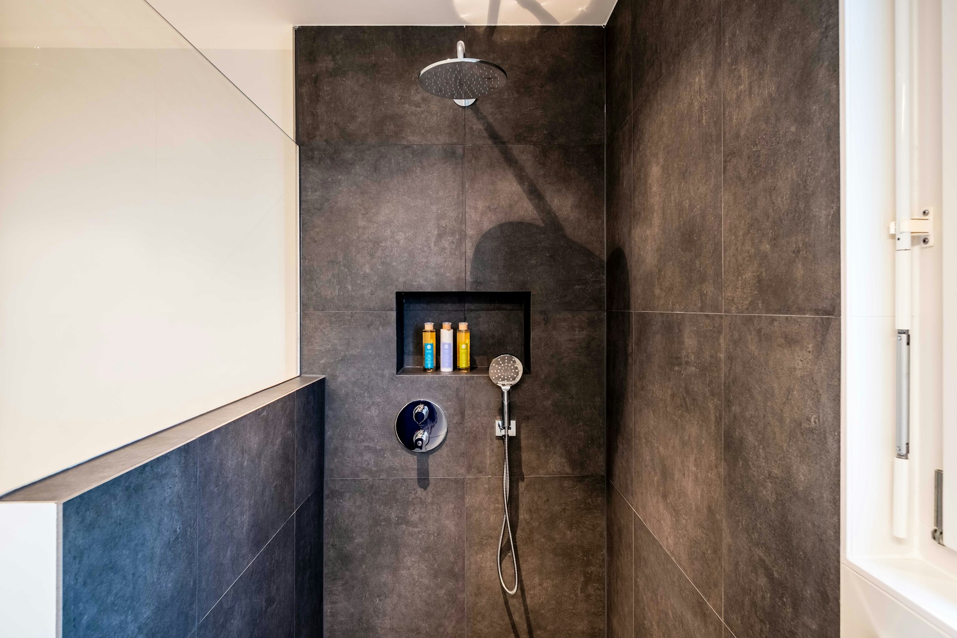 stainless steel shower head on white ceramic wall tiles