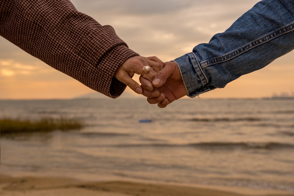 person in blue denim jeans and brown and white checked shirt holding hands with woman in near near on near