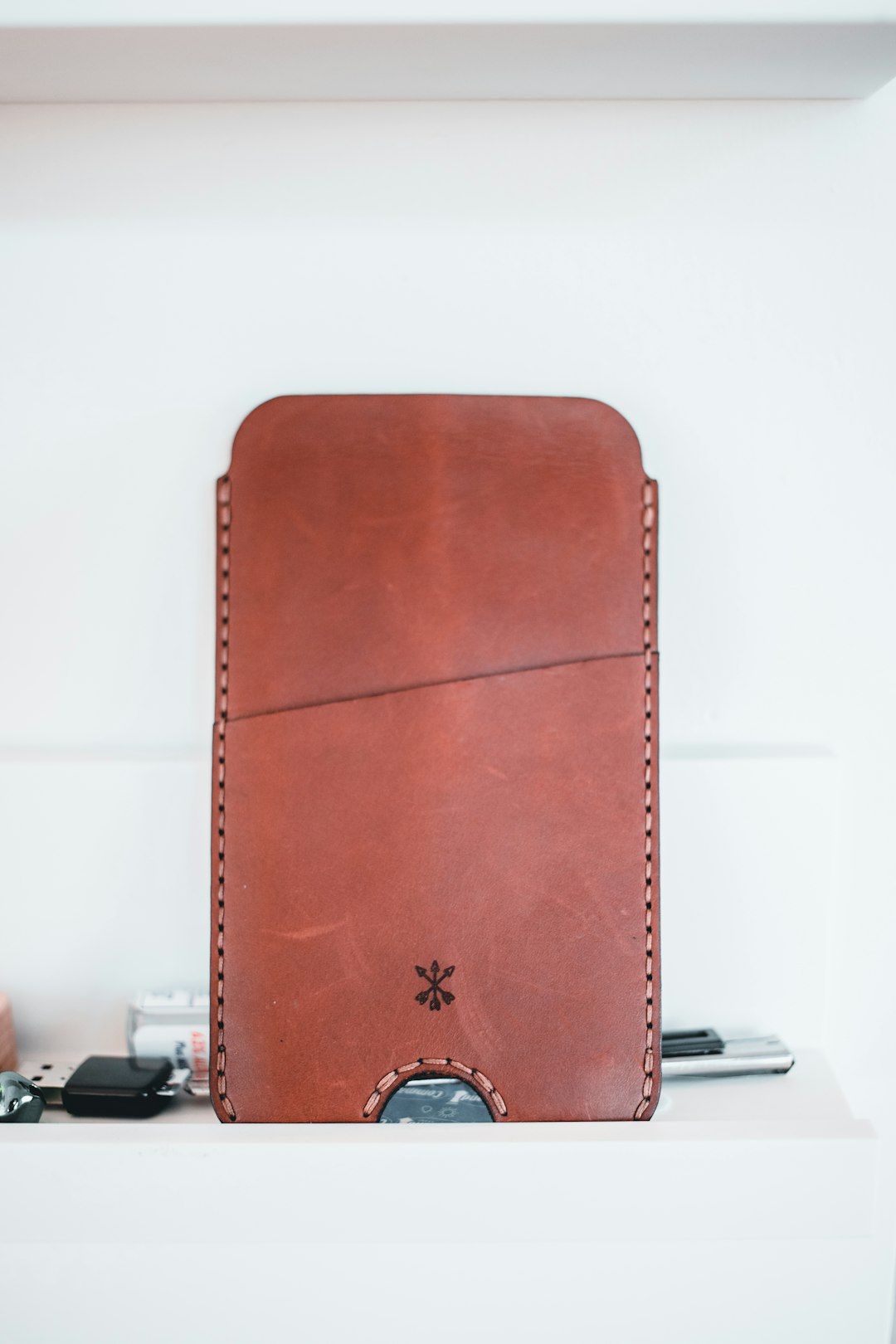 brown leather long wallet on white table