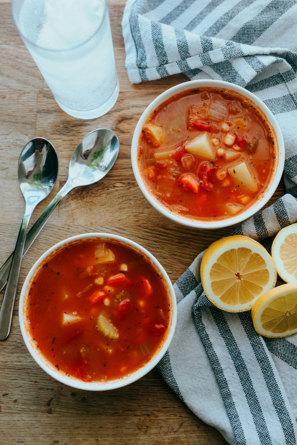 zuppa in ciotola di ceramica bianca accanto a limone a fette su piatto di ceramica bianca