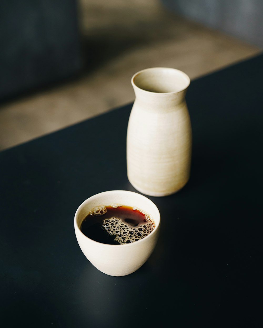 white ceramic pitcher on black table