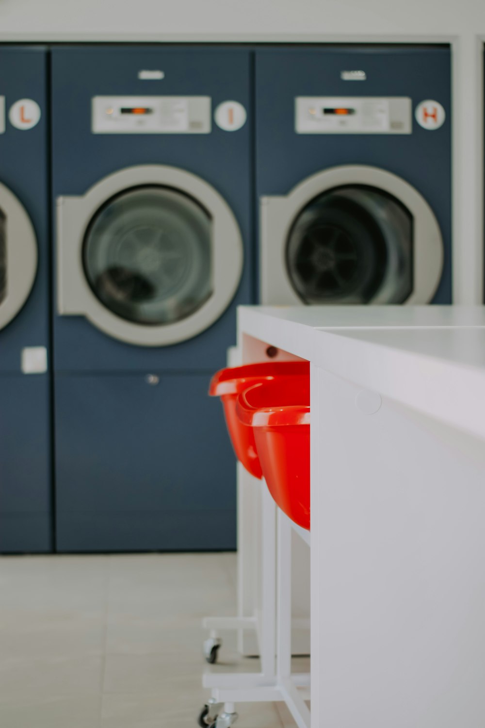 red plastic bucket on white front load washing machine