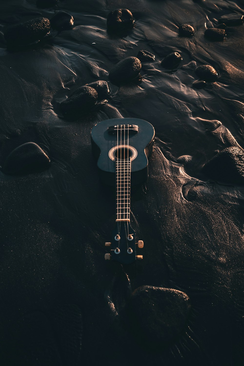 Guitare électrique blanche et noire sur sable noir