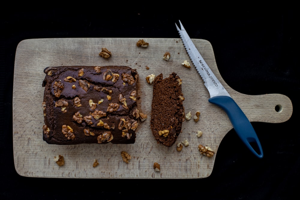 Pastel de chocolate en tabla de cortar de madera marrón