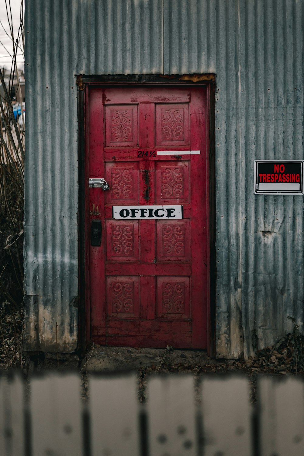 red wooden door with red and white signage