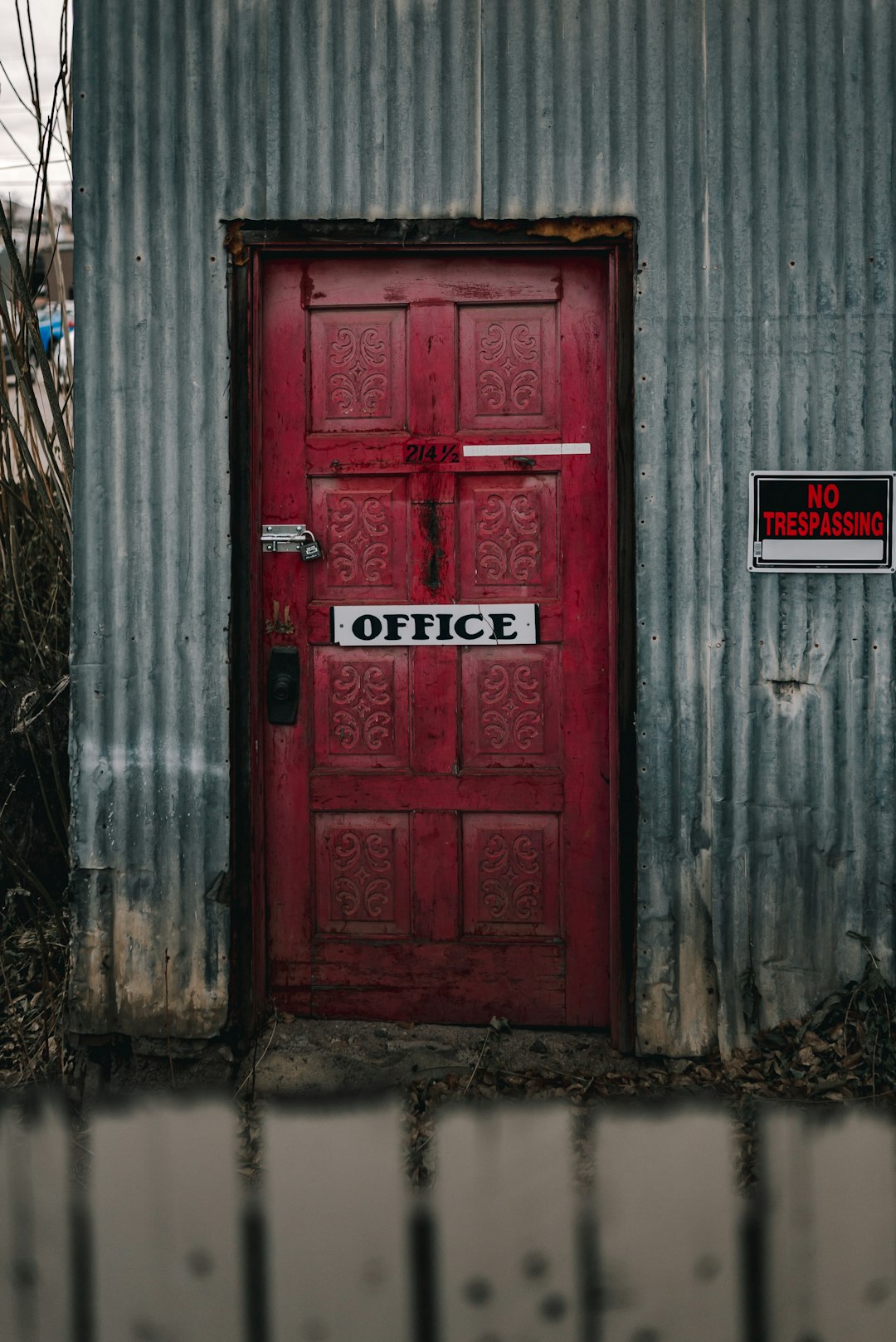 red wooden door with red and white signage