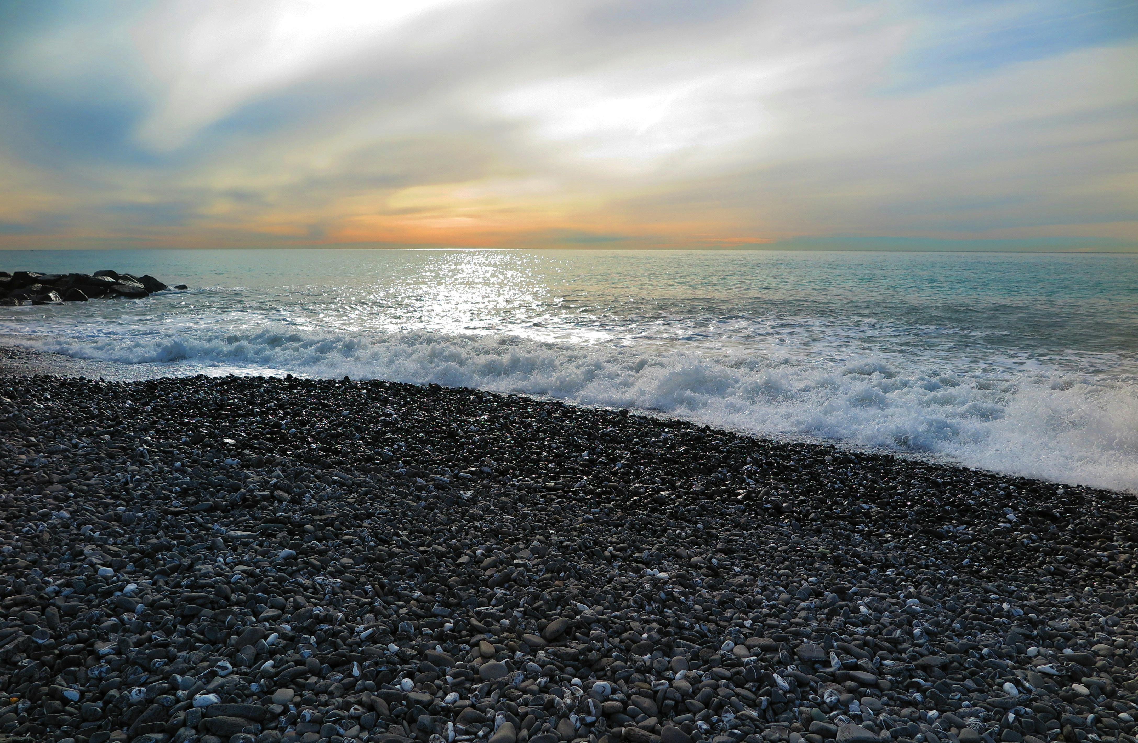 sea waves crashing on shore during sunset