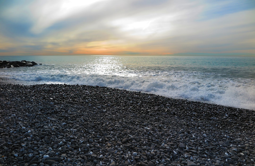 sea waves crashing on shore during sunset