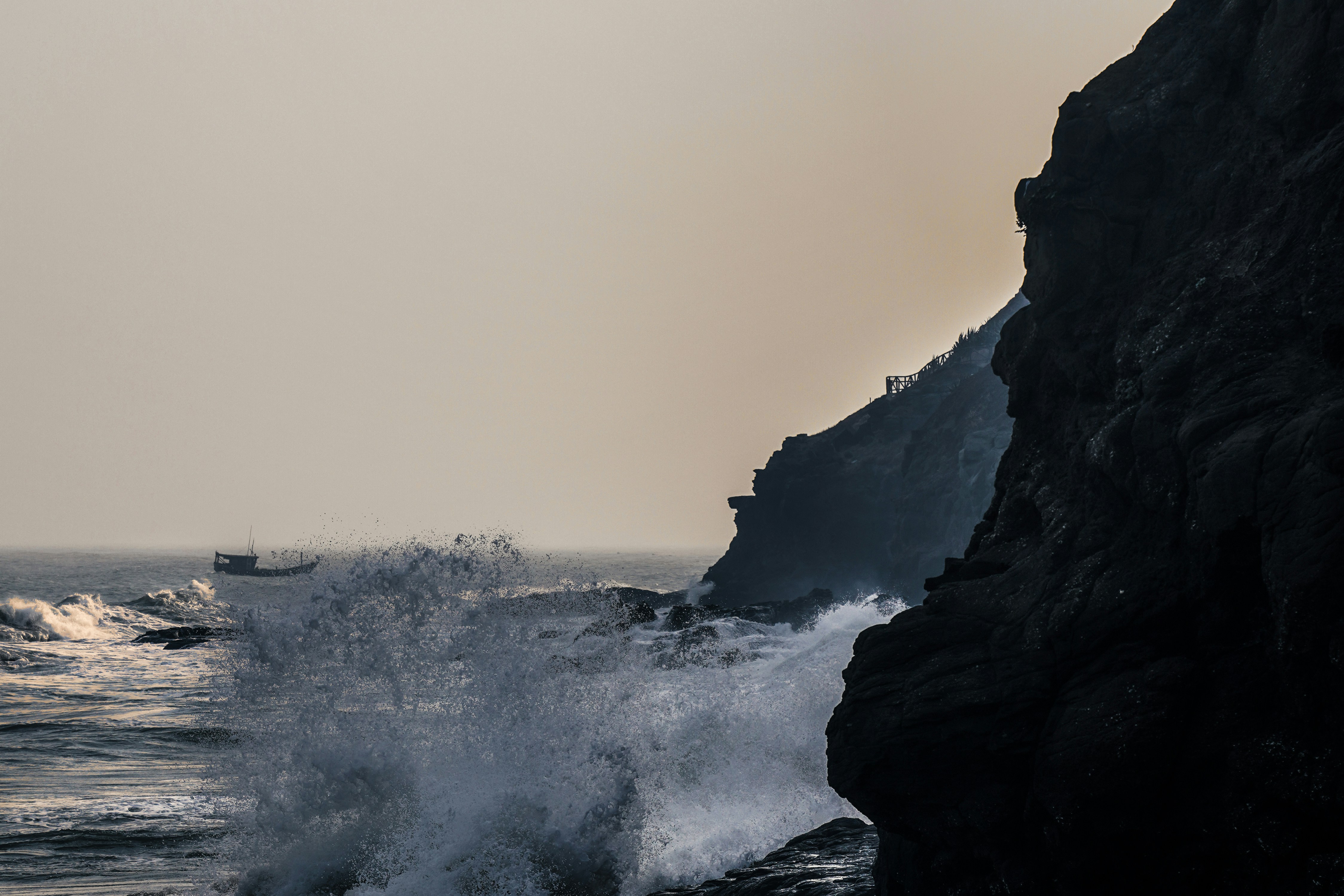 ocean waves crashing on rocky shore during foggy weather