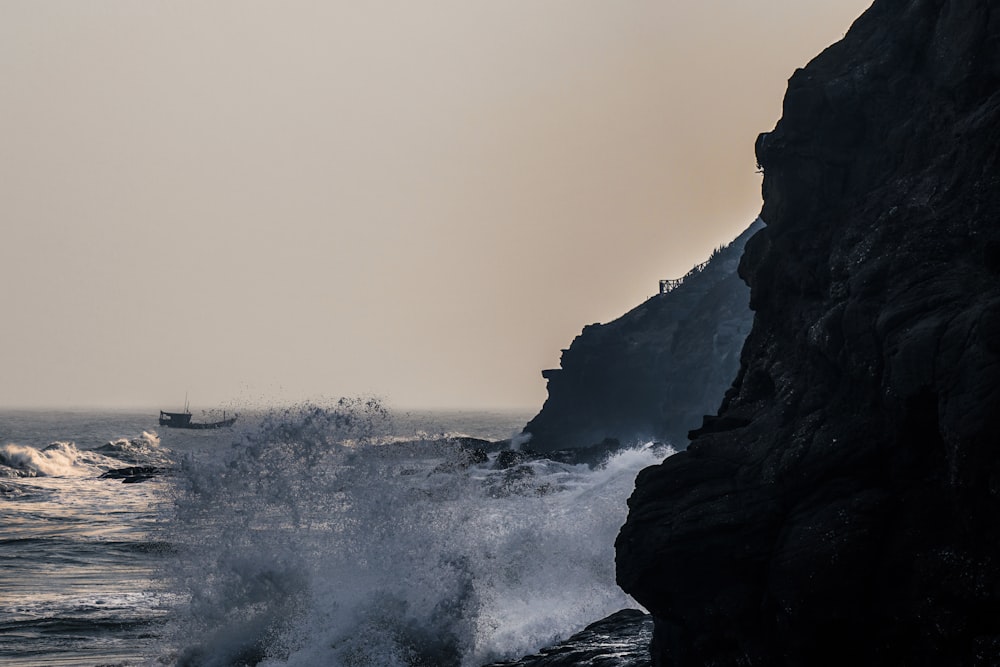 Les vagues de l’océan s’écrasent sur le rivage rocheux par temps de brouillard