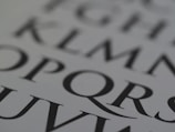 Close-up of a page with large, stylized black letters on a white background. The letters are bold and serif, capturing attention with their classic typography.