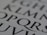 Close-up of a page with large, stylized black letters on a white background. The letters are bold and serif, capturing attention with their classic typography.