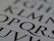 Close-up of a page with large, stylized black letters on a white background. The letters are bold and serif, capturing attention with their classic typography.