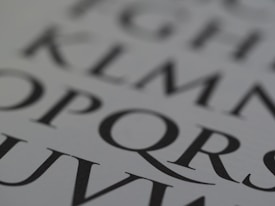 Close-up of a page with large, stylized black letters on a white background. The letters are bold and serif, capturing attention with their classic typography.