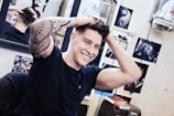 Client smiling while showing a fresh tattoo on their hand.