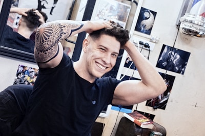 Client smiling while showing a fresh tattoo on their hand.