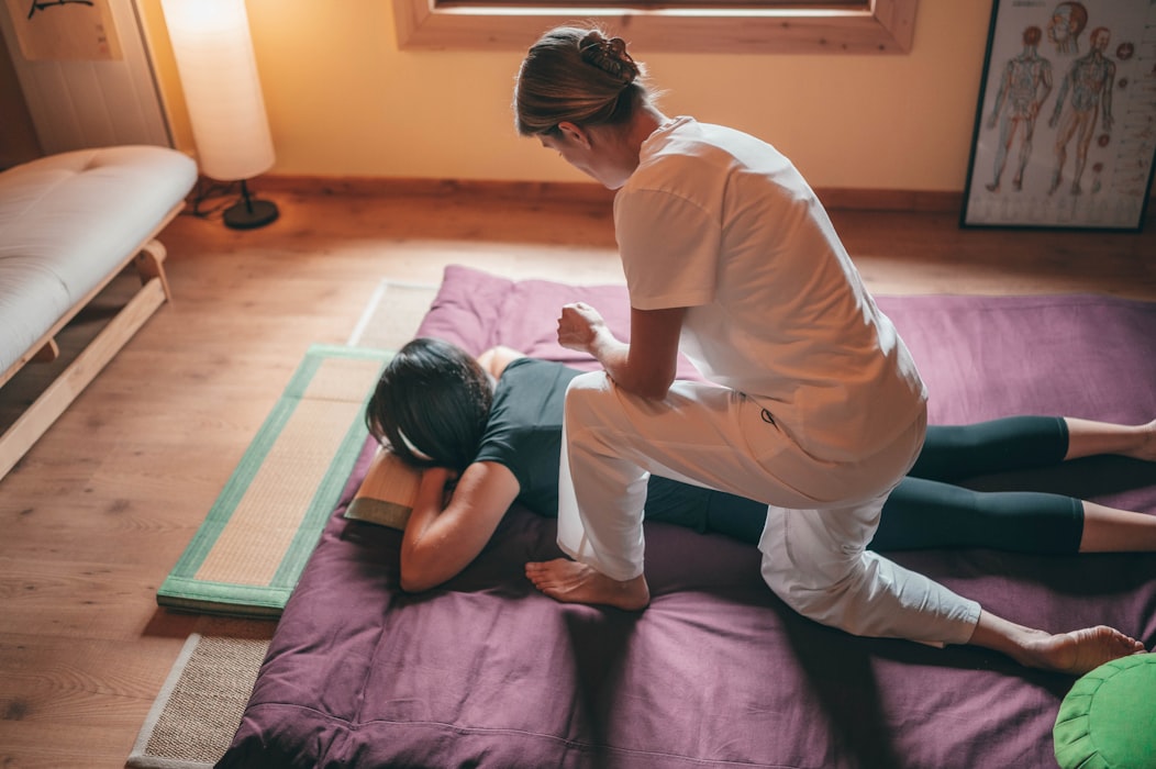 female massager therapist massaging back of a woman