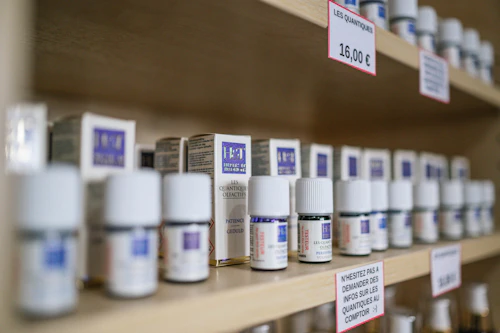Anaquel de farmacia con frascos y envases blancos ordenados