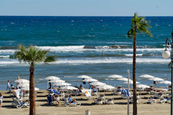 white and blue beach umbrellas on beach during daytime