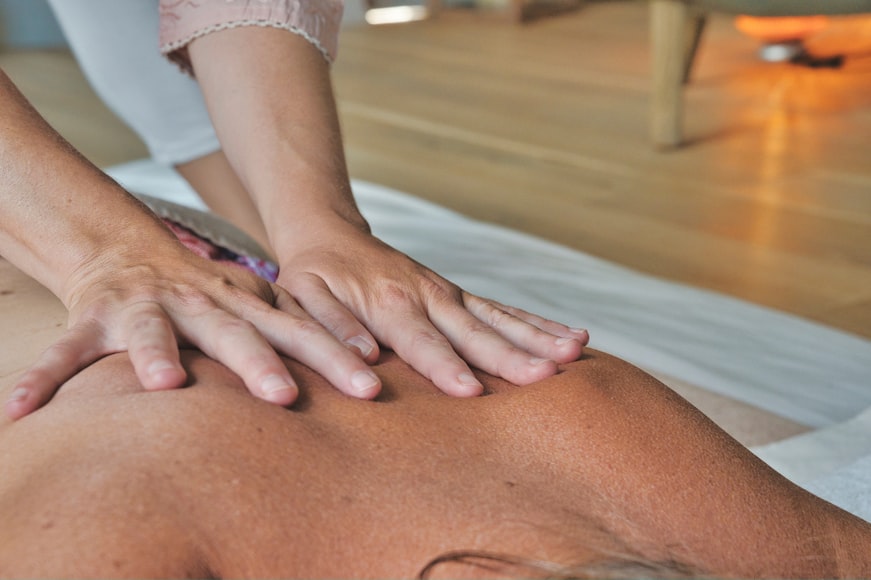 Person getting a back massage on a massage table.