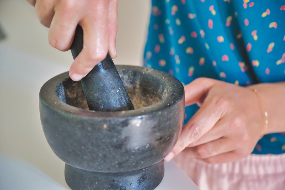 person holding gray mortar and pestle