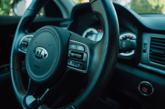 Close-up of a clean car dashboard and steering wheel with natural light.