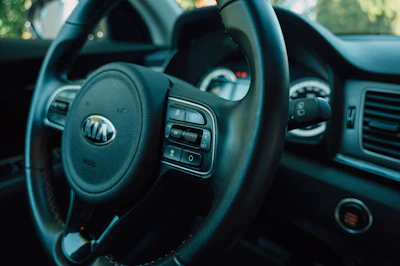 Close-up of a clean car dashboard and steering wheel with natural light.