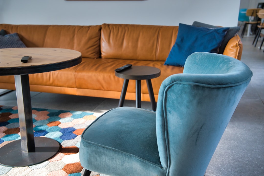 gray padded couch beside brown wooden round table