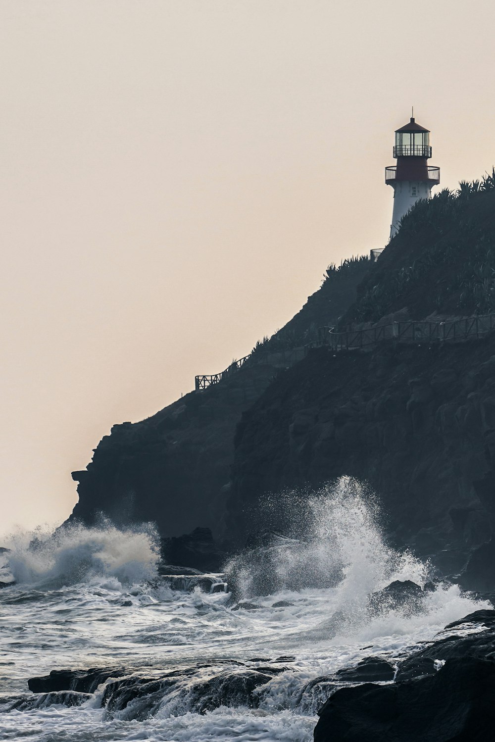 white and brown lighthouse on top of mountain