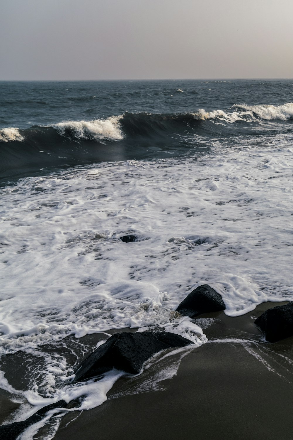 ocean waves crashing on rocks during daytime