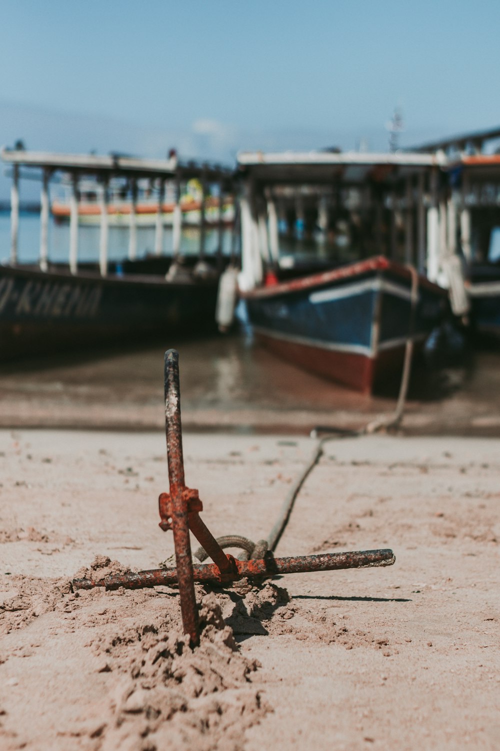 red and blue boat on brown sand during daytime