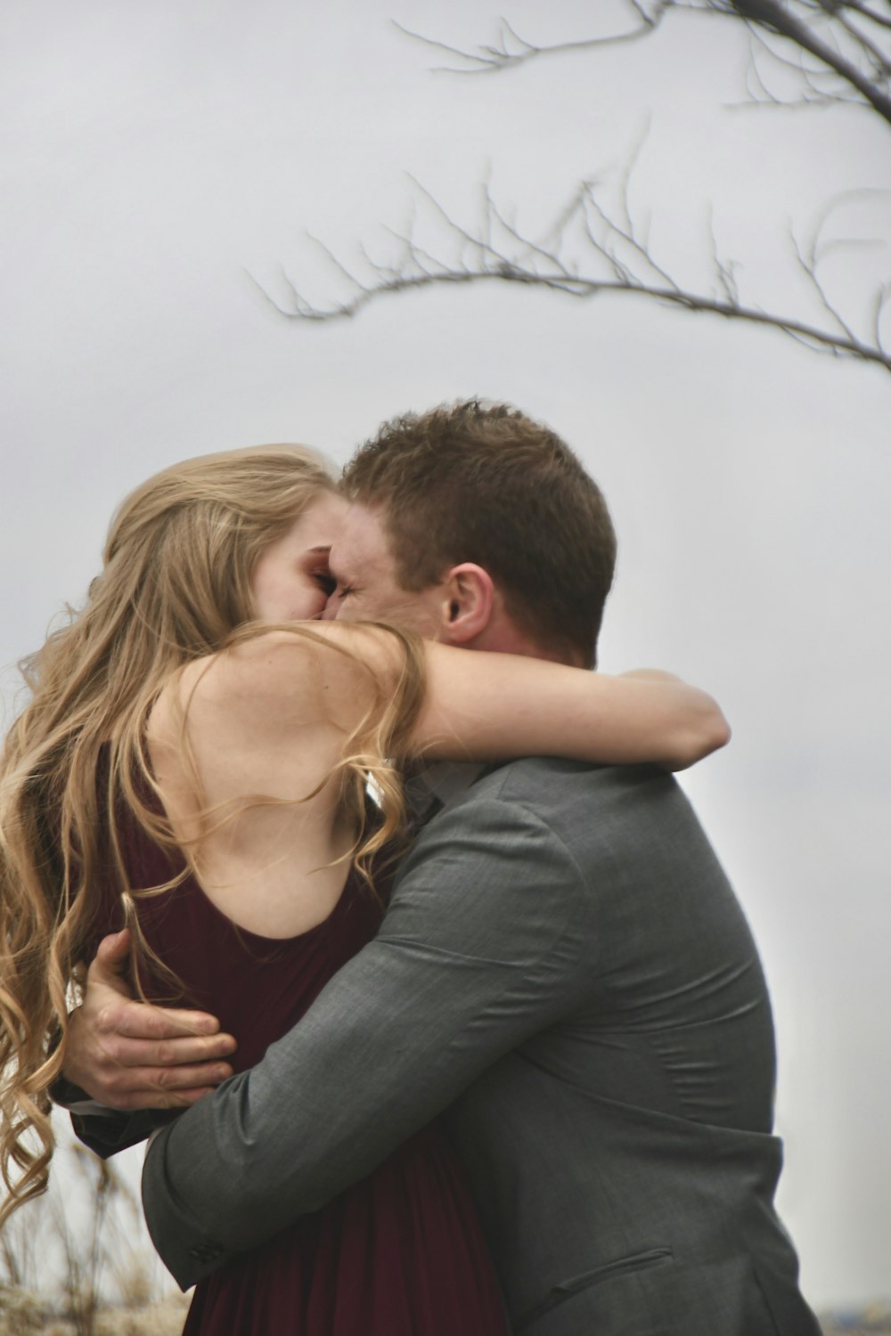 man in black tank top kissing woman in black tank top